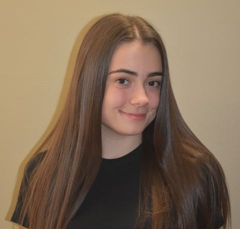 Sara Gatti smiling in front of a white wall.