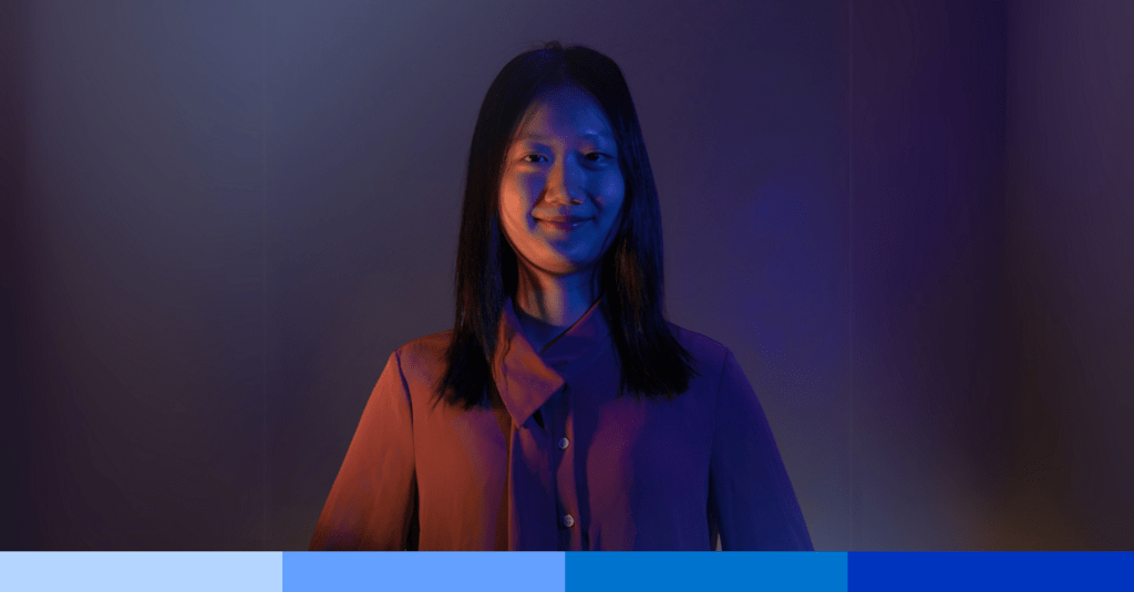 Michelle standing in front of a blue background.