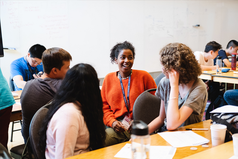A group of students talking to each other in a classroom